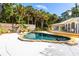 Backyard pool featuring a waterfall and surrounded by lush tropical landscaping and a wooden deck at 725 Ingham Rd, New Smyrna Beach, FL 32168