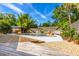 Backyard with a stunning pool, rock waterfall feature, lush landscaping, and a wooden deck at 725 Ingham Rd, New Smyrna Beach, FL 32168