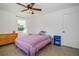 Cozy bedroom featuring a window, ceiling fan, and colorful bedspread at 902 Conrad Dr, New Smyrna Beach, FL 32168
