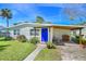Charming single-story home with a bright blue front door, landscaping and a covered front porch at 902 Conrad Dr, New Smyrna Beach, FL 32168
