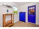 Bright kitchenette entrance with a blue door, wooden shelving and a cabinet at 902 Conrad Dr, New Smyrna Beach, FL 32168