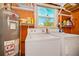 Laundry machines and water heater, with supplies and a bright window at 902 Conrad Dr, New Smyrna Beach, FL 32168