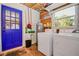 Functional laundry area with a blue door, washer, dryer, and water heater at 902 Conrad Dr, New Smyrna Beach, FL 32168