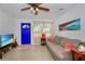 Inviting living room with a comfortable sofa, ceiling fan, and vibrant blue front door at 902 Conrad Dr, New Smyrna Beach, FL 32168