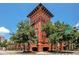 Exterior showcases a brick building featuring unique architecture and lush green trees at 911 N Orange Ave # 528, Orlando, FL 32801