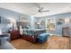 Tranquil bedroom offers a king bed, light blue walls, wood floors, and a ceiling fan at 94 Bella Vita Way, Ormond Beach, FL 32174