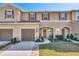 Inviting townhome with a well-maintained lawn and appealing neutral-tone exterior paint and garage at 94 Bella Vita Way, Ormond Beach, FL 32174