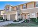 Charming townhome with tan siding, brown shutters, well manicured lawn, and an inviting front entryway at 94 Bella Vita Way, Ormond Beach, FL 32174
