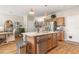 Modern kitchen with stainless steel appliances, island with seating, and wood look flooring at 94 Bella Vita Way, Ormond Beach, FL 32174