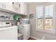 Well-lit laundry room features white washer and dryer, and a large window with neighborhood views at 94 Bella Vita Way, Ormond Beach, FL 32174