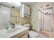 Well-lit bathroom with patterned wallpaper featuring a sink, toilet, and shower with a glass door at 101 N Riverside Dr # 214, New Smyrna Beach, FL 32169