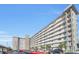 Low angle exterior shot of condominium building with balconies, covered parking and mature landscaping at 101 N Riverside Dr # 214, New Smyrna Beach, FL 32169