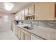 Kitchen features wood cabinets, white appliances, and a granite countertop with tiled backsplash at 101 N Riverside Dr # 214, New Smyrna Beach, FL 32169