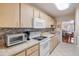Well-lit kitchen with white appliances, countertops, and light wood cabinetry at 101 N Riverside Dr # 214, New Smyrna Beach, FL 32169