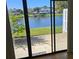 View from backyard overlooking the lake, featuring lush greenery, trees, and a glimpse of the neighbor's dock at 108 Lake Fairgreen Cir, New Smyrna Beach, FL 32168