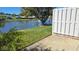 Backyard view of a lake featuring a landscaped lawn with greenery and trees, alongside houses in the neighborhood at 108 Lake Fairgreen Cir, New Smyrna Beach, FL 32168