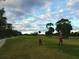 Golf course with a lush green, tree-lined fairway, and two golfers at 108 Lake Fairgreen Cir, New Smyrna Beach, FL 32168