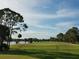 Beautiful golf course with a lake, set against a blue sky at 108 Lake Fairgreen Cir, New Smyrna Beach, FL 32168