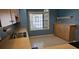 Compact kitchen featuring tile flooring, laminate countertop, and a bright window above the sink at 108 Lake Fairgreen Cir, New Smyrna Beach, FL 32168