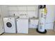 Garage laundry area with washer, dryer, utility sink, and water heater at 108 Lake Fairgreen Cir, New Smyrna Beach, FL 32168
