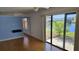A living room with wood flooring, a ceiling fan, and a large sliding door with a view of the lake at 108 Lake Fairgreen Cir, New Smyrna Beach, FL 32168