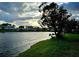 Scenic water view with lush green landscaping and a tranquil and serene atmosphere at sunset at 108 Lake Fairgreen Cir, New Smyrna Beach, FL 32168
