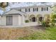 Spacious backyard with a patio area, mature trees, and a white stucco home with black shutters at 111 Esther St, New Smyrna Beach, FL 32169