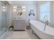 Well-lit bathroom with a soaking tub, glass shower, vanity, and patterned tile flooring at 111 Esther St, New Smyrna Beach, FL 32169