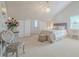 Bright bedroom with a high ceiling, neutral color palette, and a decorative chandelier above the bed at 111 Esther St, New Smyrna Beach, FL 32169