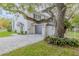 Charming two-story white home with gray accents, a driveway, and mature landscaping at 111 Esther St, New Smyrna Beach, FL 32169