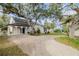 Charming home with beautiful landscaping, mature trees, and a welcoming front entrance with classic architectural details at 111 Esther St, New Smyrna Beach, FL 32169