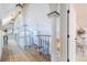 Open-concept hallway with curved staircase, pillars, and abundant natural light at 111 Esther St, New Smyrna Beach, FL 32169