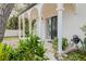 Inviting front porch with classic columns, a charming entrance, and well-manicured landscaping at 111 Esther St, New Smyrna Beach, FL 32169