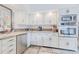Well-lit kitchen with stainless steel appliances and white cabinetry at 111 Esther St, New Smyrna Beach, FL 32169