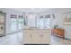 Bright, airy kitchen boasts a center island with countertop range and ample natural light from surrounding windows and French doors at 111 Esther St, New Smyrna Beach, FL 32169