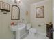 Charming powder room with pedestal sink and decorative mirror and artwork at 111 Esther St, New Smyrna Beach, FL 32169