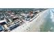 Panoramic drone shot of beachfront apartments and shops, with ocean views and nearby amenities at 111 N Atlantic Ave # A219, New Smyrna Beach, FL 32169