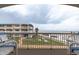 Relaxing beach view from the balcony showcasing the building, lawn area, beach and ocean at 111 N Atlantic Ave # A219, New Smyrna Beach, FL 32169