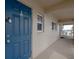 Exterior view of the unit entrance, featuring a blue door, porch and a partial beach view at 111 N Atlantic Ave # A219, New Smyrna Beach, FL 32169