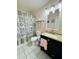 Bathroom featuring a stylish vanity, decorative mirror, and shower with patterned curtain at 1136 Elizabeth St, New Smyrna Beach, FL 32168