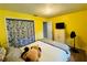 Bedroom featuring yellow walls, wood floors, and a closet with a floral curtain at 1136 Elizabeth St, New Smyrna Beach, FL 32168