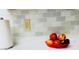 A pristine kitchen counter features a stylish backsplash, complementing the vibrant arrangement of fresh fruit at 1136 Elizabeth St, New Smyrna Beach, FL 32168