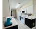 Bright kitchen featuring white appliances, marble countertops, backsplash, and stylish white and black cabinetry at 1136 Elizabeth St, New Smyrna Beach, FL 32168