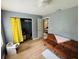 Inviting living room with wood floors, futon, closet with curtain, and neutral wall paint at 1136 Elizabeth St, New Smyrna Beach, FL 32168