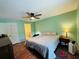 A spacious main bedroom featuring a ceiling fan, hardwood floors, and attached bathroom at 1136 Elizabeth St, New Smyrna Beach, FL 32168