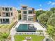 Aerial view of a modern home with a backyard oasis, featuring a pool, fire pit, and manicured lawn at 1194 N Peninsula, New Smyrna Beach, FL 32169