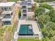 Aerial view of a modern home with a pool, surrounded by lush greenery and a neighboring construction at 1194 N Peninsula, New Smyrna Beach, FL 32169