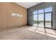 Bright bedroom with a wood accent wall, large window, and access to a waterfront balcony at 1194 N Peninsula, New Smyrna Beach, FL 32169
