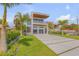 Modern home with sleek design, a spacious driveway, and lush landscaping with palm trees at 1194 N Peninsula, New Smyrna Beach, FL 32169