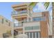 Stunning multi-story home featuring expansive balconies with glass railings and modern wood accents at 1194 N Peninsula, New Smyrna Beach, FL 32169